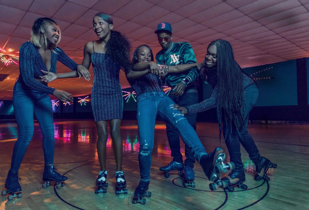 A group of young Black skaters enjoying their time at the rink.