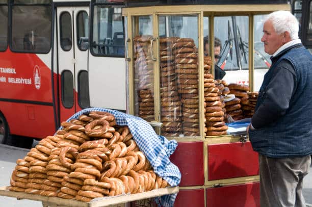 Istanbul vendor preparing simit bread rings by the street.