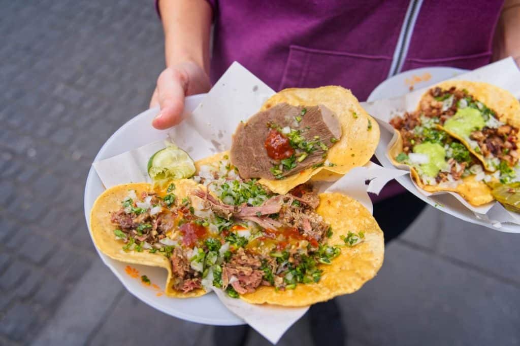 Street vendor serving tacos al pastor in Mexico City
