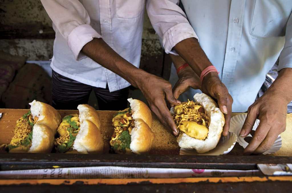 Vendor in Mumbai serving vada pav on the street